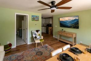 a living room with a table and a ceiling fan at Grateful Manor-Close to Downtown- Sauna in Livingston Manor