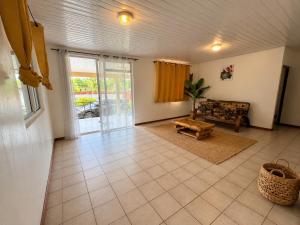 a living room with a couch and a table at Tevaatua house in Papara