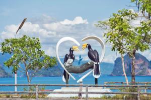 a statue of two birds sitting in a heart at Affordable shack in Ko Yao Noi +13 photos