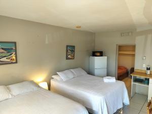 a hotel room with two beds and a refrigerator at Studio in Hallandale 2270 in Hallandale Beach