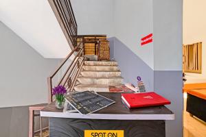 a staircase with a table with books and a red notebook at Hotel O SS in Chandrapur