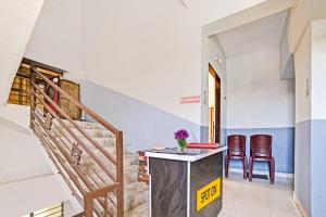a hallway with stairs and a table and chairs at Hotel O SS in Chandrapur