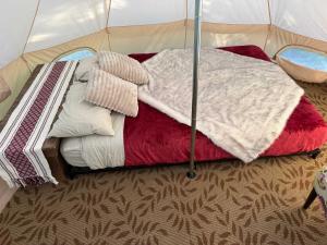 a tent with a bunch of blankets and pillows at Willowbank Bell Tent in Golden