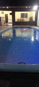 a swimming pool with blue water in a building at Refúgio Serenna in Bebedouro