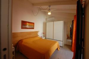 a bedroom with a orange bed in a room at Casa Vacanza "Donna Franca" in Castellammare del Golfo