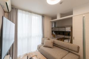a living room with a couch and a bunk bed at Rubens Hakata -ルーベンス博多- in Fukuoka