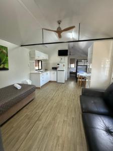 a living room with a bed and a kitchen at Kookaburra Holiday Park in Cardwell