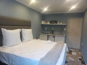 a bedroom with a large bed with white pillows at Lifeshed in Johannesburg +1 photo