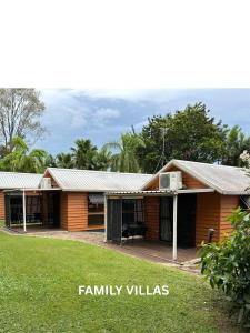 a house with a yard in front of it at Kookaburra Holiday Park in Cardwell