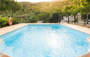 a large blue swimming pool with a fence at Los Moreno in Laroya