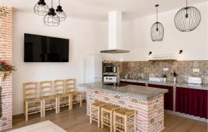 a kitchen with a counter and a bar with stools at Los Moreno in Laroya