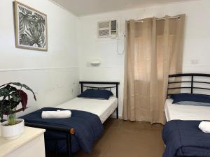 a room with two beds and a plant in it at Kookaburra Holiday Park in Cardwell +21 photos