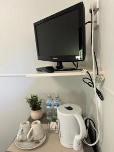 a computer monitor sitting on a shelf with water bottles at Kookaburra Holiday Park in Cardwell