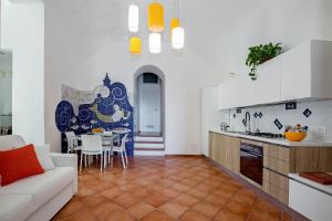 a kitchen and living room with a couch and a table at Starhost - CASA BETTINA enchanting seaview in Vietri sul Mare +18 photos