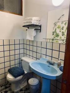 a bathroom with a blue sink and a toilet at Apart Hotel Colon in La Serena +12 photos