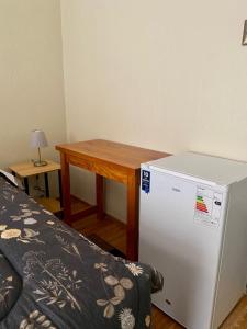 a small room with a table and a refrigerator at Apart Hotel Colon in La Serena
