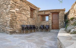 a group of chairs sitting in front of a stone building at Yerbaluisa in Laroya