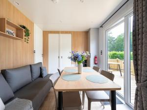 a living room with a table and a couch at Comfortable caravan in a green setting in Vierhuizen
