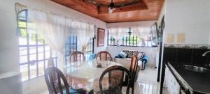 a dining room with a glass table and chairs at Casa Vacacional Algarrobos in Girardot
