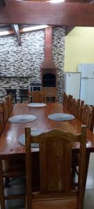 a large wooden table in a room with a fireplace at Refúgio Serenna in Bebedouro +2 photos