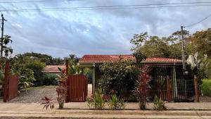 a house with a gate and plants in front of it at Casa Pentagonia in Puerto Jiménez