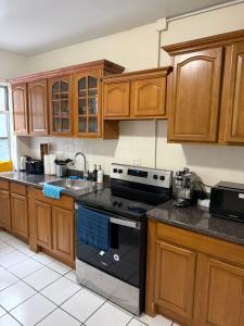a kitchen with wooden cabinets and a black stove top oven at Madison - Shared apartment in New York