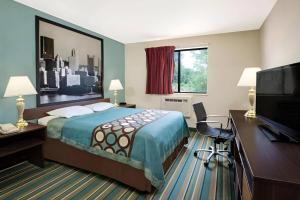 a hotel room with a bed and a flat screen tv at Pittsburgh Royal Hotel in Moon Township