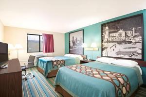 a hotel room with two beds and a flat screen tv at Pittsburgh Royal Hotel in Moon Township