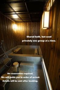 a bathroom with a bathtub with a sign on it at Ryokan Tori in Kyoto