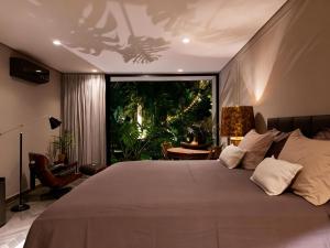 a bedroom with a large bed and a large window at Exclusive Oásis by Lotta De Macedo Soares in Petrópolis +84 photos