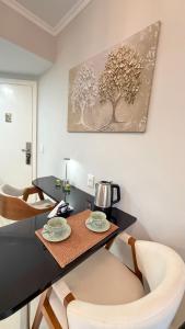 a dining room table with a coffee pot and chairs at Ibirapuera Privilege - Suíte Deluxe Moema in São Paulo