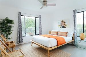 a bedroom with a bed and a chair and windows at Hotel El Cid by AvantStay in Palm Springs +18 photos