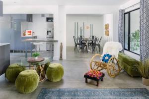 a living room with a couch and a table and chairs at Hotel El Cid by AvantStay in Palm Springs