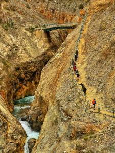 a group of people walking up a hill next to a river at Colpapampa Lodge in Colcapampa