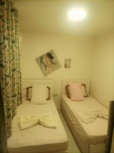 a small room with two beds and a picture on the wall at Asala Village, Blue Bay Resort, Marsa Matrouh in Marsa Matruh +9 photos