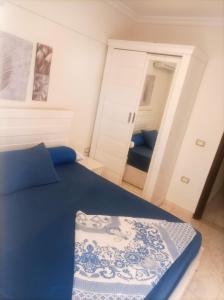 a bedroom with a blue bed and a mirror at Asala Village, Blue Bay Resort, Marsa Matrouh in Marsa Matruh