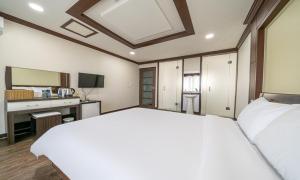 a bedroom with a large white bed and a desk at Mobydick Hotel in Yangyang +11 photos