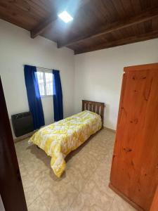 a bedroom with a bed with a yellow comforter at aura in La Falda