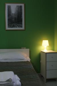 ペスカーラにあるBed & Breakfast Flaianoの緑豊かなベッドルーム(ベッド1台、ランプ付きのナイトスタンド付)