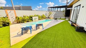 a backyard with a swimming pool and green grass at Villa Container SBO Refúgio Urbano com piscina e jacuzzi in Santa Bárbara dʼOeste