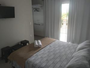 a bedroom with a bed with two towels on it at Pousada altavista acuruí in Itabirito +13 photos