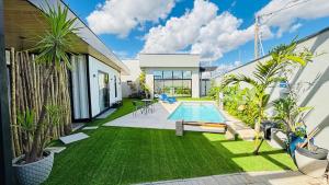 a backyard with a swimming pool and green grass at Villa Container SBO Refúgio Urbano com piscina e jacuzzi in Santa Bárbara dʼOeste