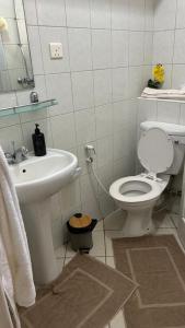 a white bathroom with a toilet and a sink at RESIDENCE CYBERVILLAGE THREE ROOMS Apartment in Ebene