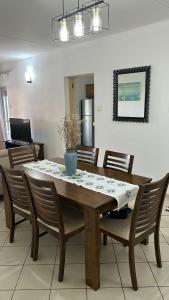 a dining room table with chairs and a vase on it at RESIDENCE CYBERVILLAGE THREE ROOMS Apartment in Ebene