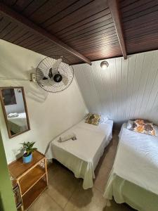 a room with two beds and a fan at Chale do Índio - Ilha Grande in Angra dos Reis