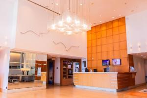 eine Lobby mit einem Kronleuchter, der von der Decke hängt in der Unterkunft Wyndham Macae in Macaé