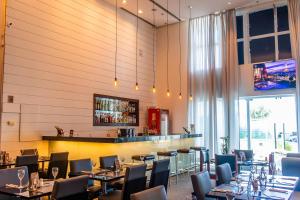 ein Restaurant mit Tischen und Stühlen und einer Bar in der Unterkunft Wyndham Macae in Macaé