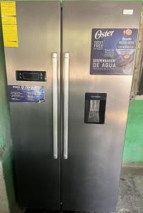 a stainless steel refrigerator with a sign on it at Casa Aquino in Santa Cruz Analquito