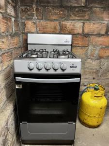 a gas stove sitting next to a brick wall at Casa Aquino in Santa Cruz Analquito