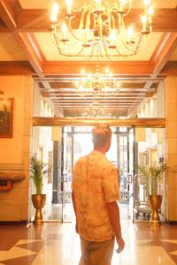 a man walking through a building with a chandelier at Hotel Gillow in Mexico City
